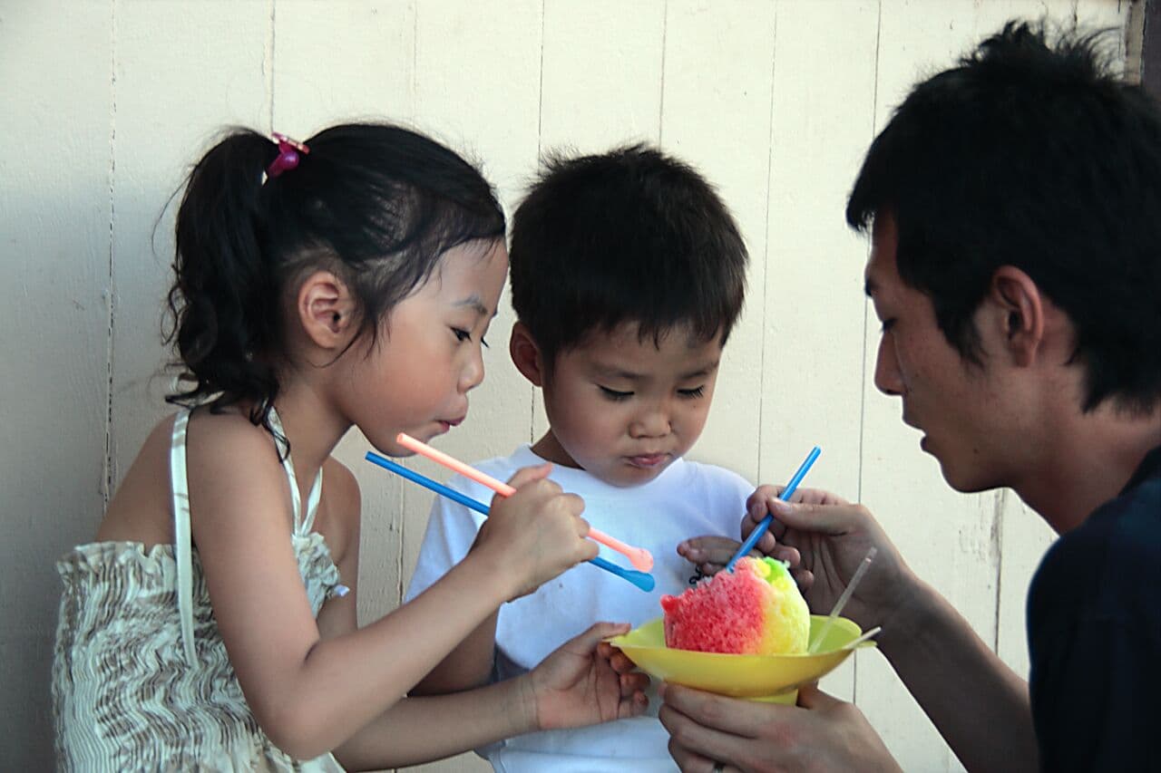 Two young tourists enjoying a shave ice at Matsumoto's Grocery Store in Haleiwa on Oahu.